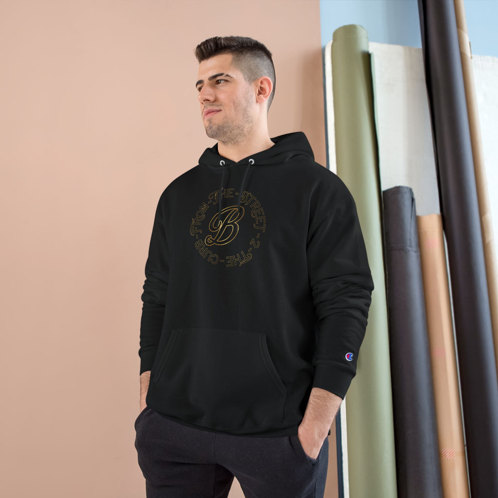 Man wearing black streetwear hoodie with gold 'From The Street' graphic, Champion logo on sleeve