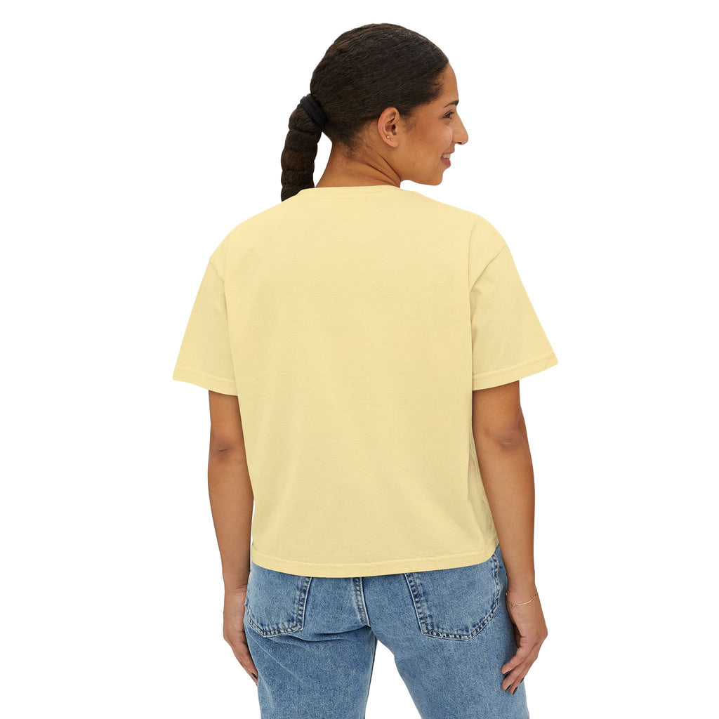 Woman wearing a pale yellow oversized graphic tee with blue jeans, streetwear style